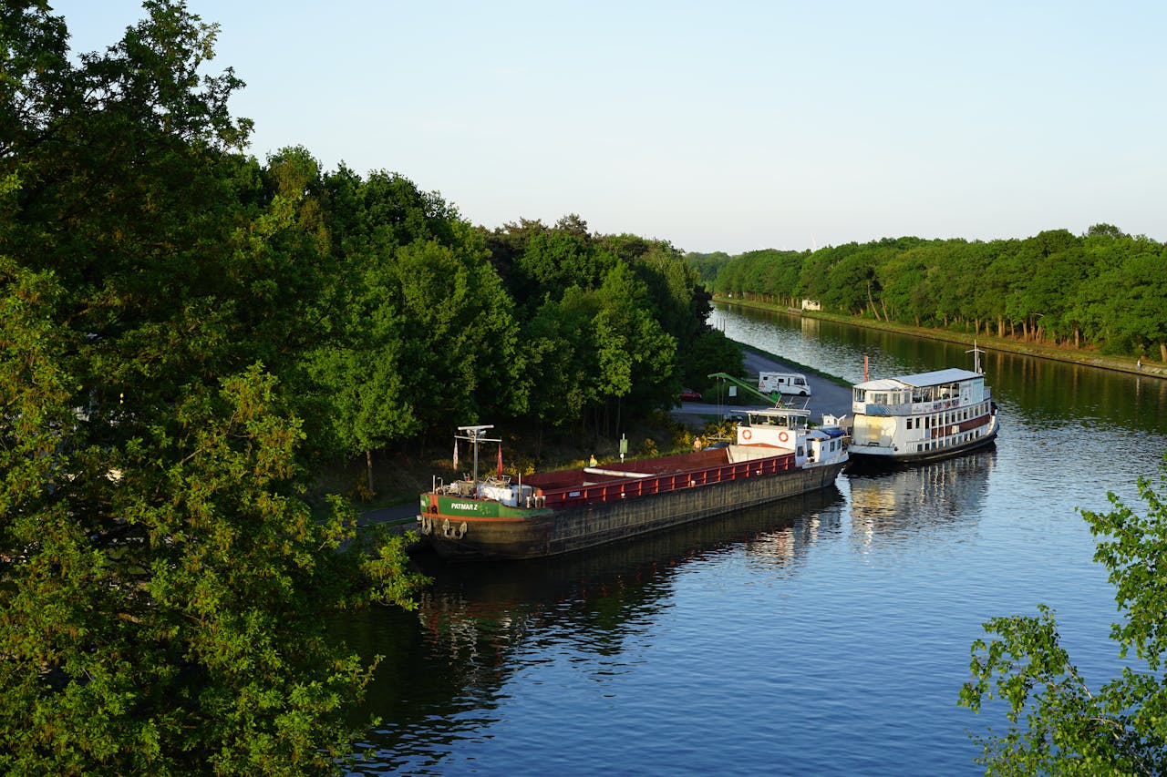 Charming summer view of boats moored along a tranquil canal in Dessel, Belgium.