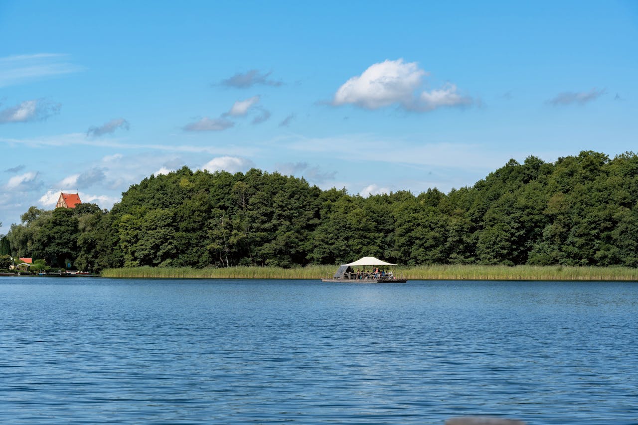 contact-img Tranquil summer day at a pristine lakeside with a raft and lush green forest backdrop.