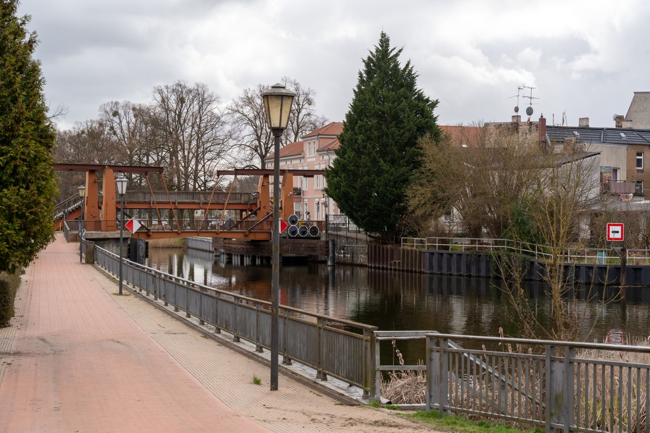 Scenic view of a canal with drawbridge in a small European town, perfect for tourism.